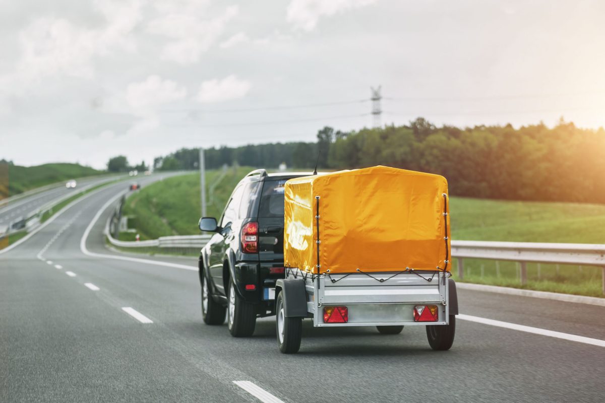 SUV and Rental Cargo Trailer on a Road. Efficient moving.